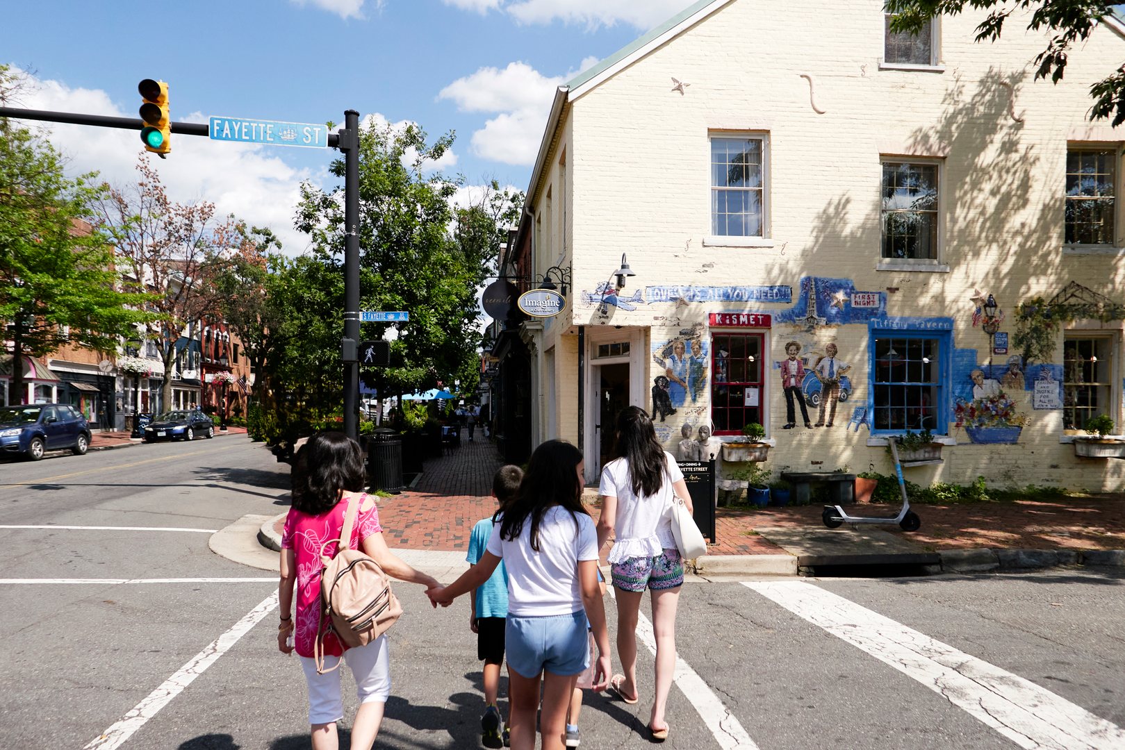 A family crosses in the crosswalk at Fayette and King on a bright summer day