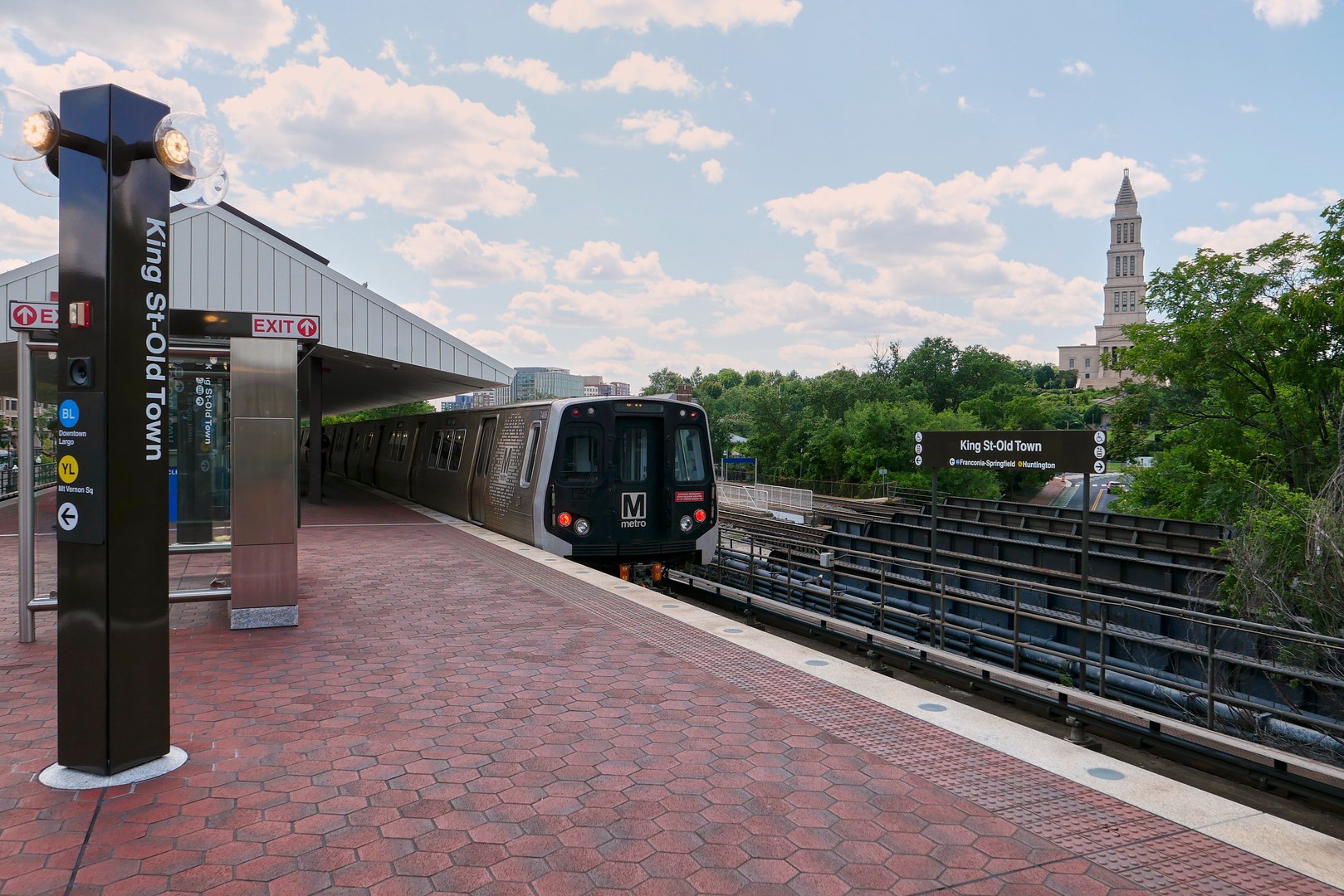 A shot from the metro platform of a train pulling up, with the Masonic Temple in the background