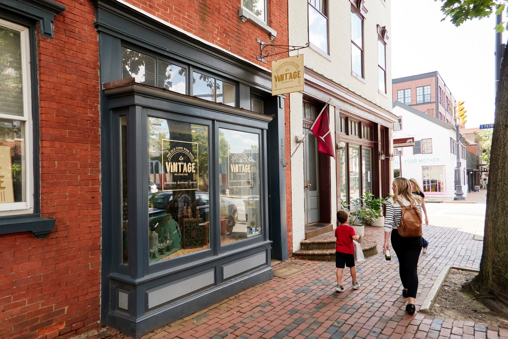 A woman and child walking past a vintage store